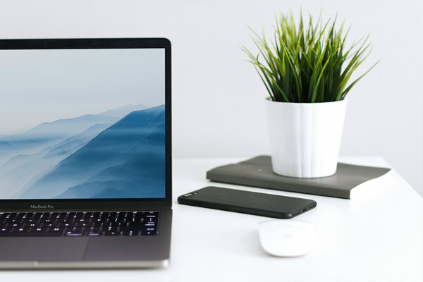 iPhone und Macbook liegen auf Tisch