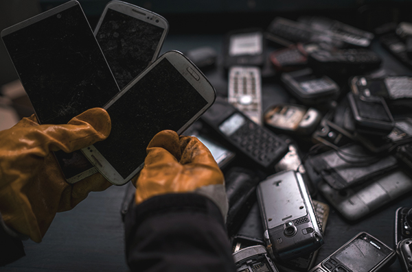 Mann hält alte Smartphones in den Händen