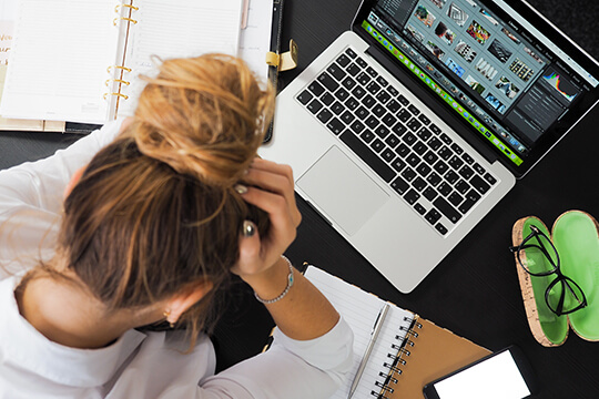 Frau bearbeitet Bilder am Laptop